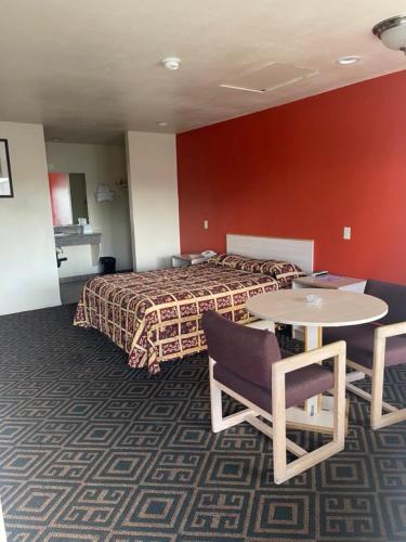a hotel room with a bed and a table and chairs at Star Lodge Motel-Oceanside in Vista
