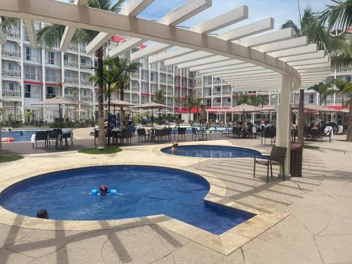 a person swimming in a swimming pool under a large building at Thermas São Pedro Park Resort in São Pedro