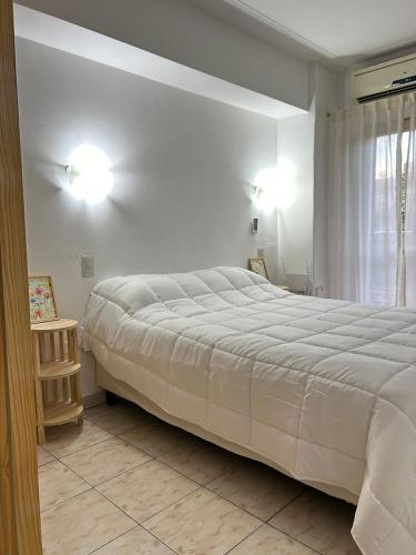 een slaapkamer met een groot wit bed en een raam bij Monoambiente amoblado in San Miguel de Tucumán