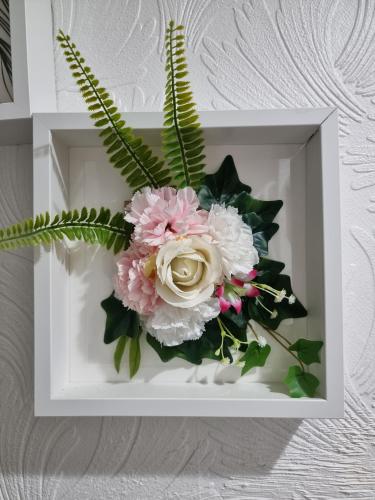 a white box with a bouquet of flowers in it at Modern 3 bedroom house, 3 Bathroom, secure parking, Wi-Fi & Garden in Leeds