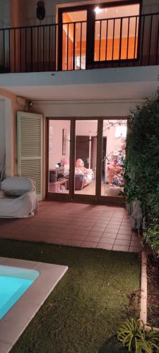 dom z dużymi szklanymi drzwiami i łóżkiem na zewnątrz w obiekcie Can Romaní - Casa compartida con propietario - Baño compartido w mieście L'Escala