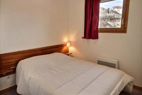 une chambre avec un lit blanc et une fenêtre dans l'établissement Cozy 6-person apartment with balcony, à Saint-Étienne-en-Dévoluy