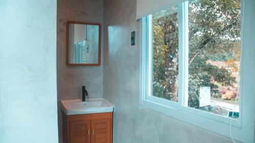 baño con lavabo y ventana en Como River Retreat en Cavinti