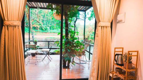 un porche con cortinas, una mesa y una planta en Como River Retreat en Cavinti