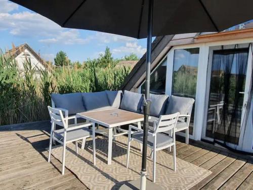 une table et des chaises avec un parasol sur une terrasse dans l'établissement Ein bisschen Luxusfeeling direkt am Neusiedler See, à Rust