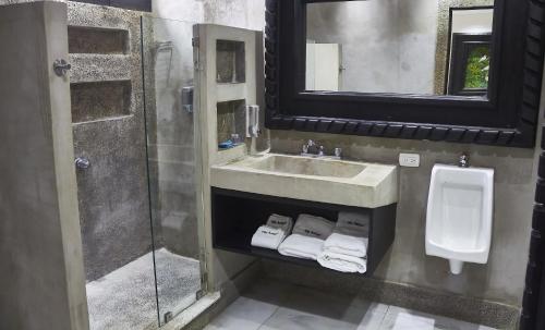 a bathroom with a sink and a toilet and a mirror at Hotel Villa Antigua in San Salvador