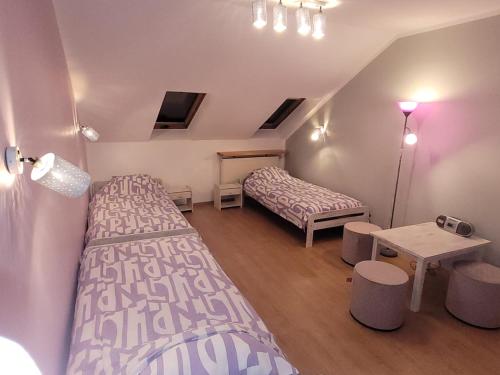 ジヴィエツにあるNa Starówceのベッド2台とテーブルが備わる小さな客室です。