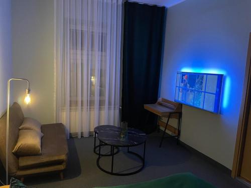 a living room with a couch and a table and a tv at Apartamenty na Starówce - Apartments in the Old Town in Cieszyn
