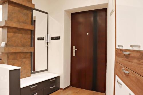 a bathroom with a wooden door and a mirror at Capital apartments Sarajevo in Sarajevo