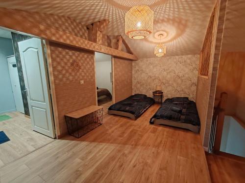um quarto amplo com 2 camas e um lustre em JolieMaison-au-34 em Angoulême