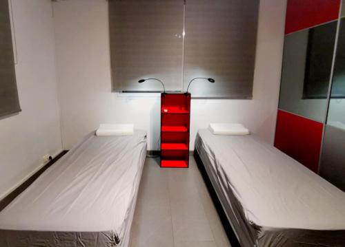 a room with two beds and a red shelf at Cocoon Island Grand F3 in Noumea