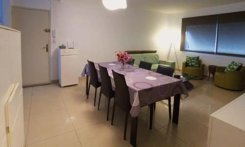 a dining room table with a purple table cloth and chairs at Cocoon Island Grand F3 in Noumea