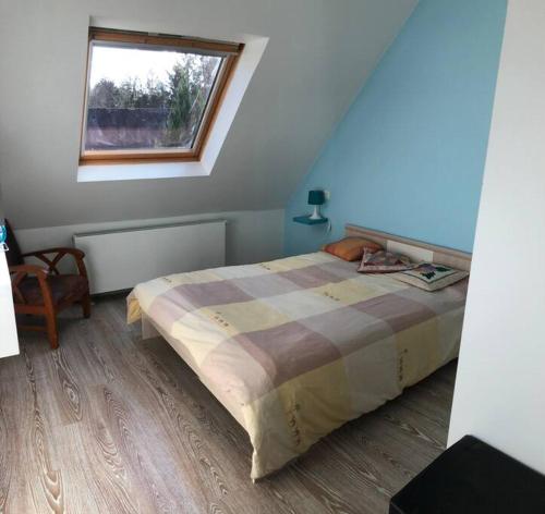 une chambre avec un grand lit avec une fenêtre dans l'établissement Ty Gabi - Maison à 20 minutes des plages, à Landaul