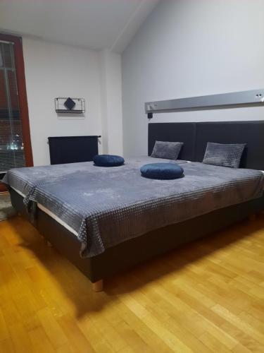 een slaapkamer met een bed met blauwe kussens erop bij Penthouse in Skopje