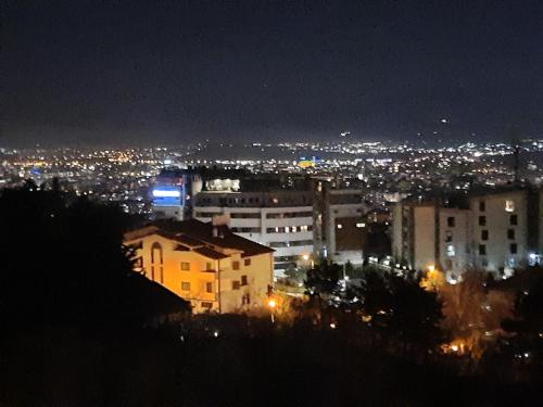 uitzicht op een stad 's nachts met verlichting bij Penthouse in Skopje