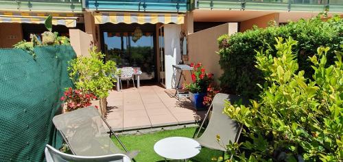 un patio avec des chaises, une table et des plantes dans l'établissement Residence Egee, à Cannes