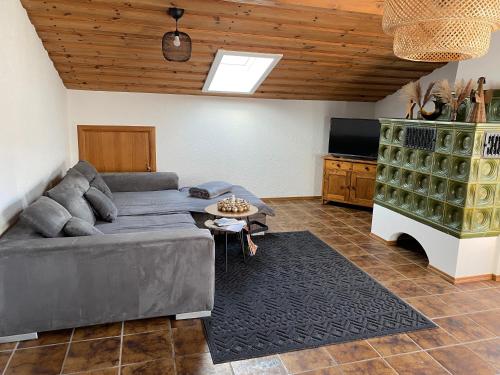 ein Wohnzimmer mit einem Sofa und einem TV in der Unterkunft Ferienwohnung Bergliebe in Staudach-Egerndach