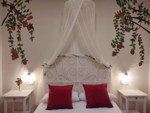 una camera da letto con un letto bianco con cuscini rossi di Alange Termal ad Alange