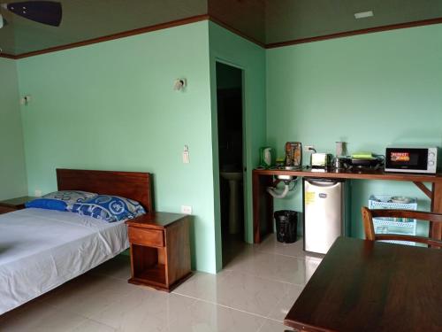 a bedroom with a bed and a table and a kitchen at Encanto Arenal lodge in Fortuna