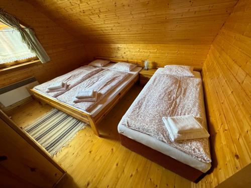 two beds in a room with wooden floors at Drevenica Donovaly in Donovaly