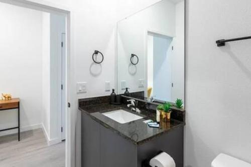 La salle de bains est pourvue d'un lavabo et d'un grand miroir. dans l'établissement 3308 - Gorgeous 3bed vacation home, à Kissimmee