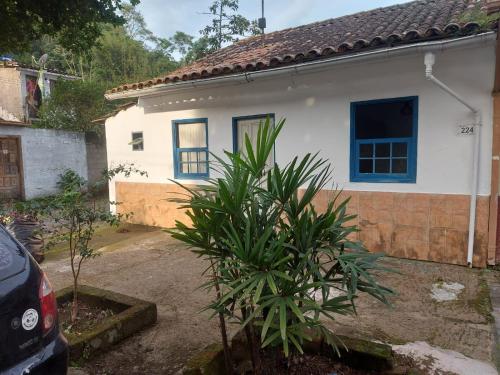 a house with a palm tree in front of it at Lar, doce mar. in Paraty