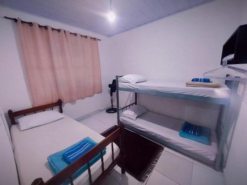 um pequeno quarto com 2 beliches e uma janela em Lar, doce mar. em Paraty