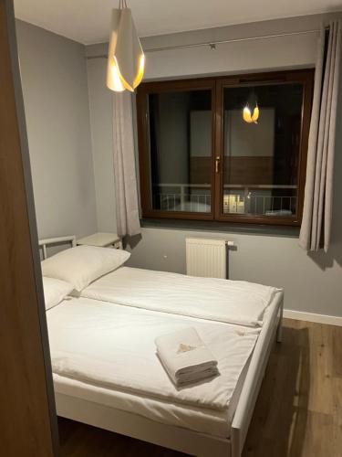 a bedroom with two beds and a window at Jab Apartment NOWE FORTY Business & Family in Szczecin