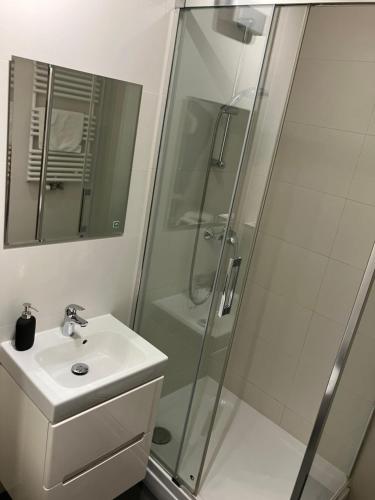 a white bathroom with a shower and a sink at Jab Apartment NOWE FORTY Business & Family in Szczecin