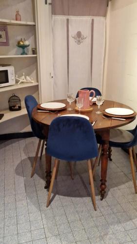 a dining room table with blue chairs and a wooden table at Le Gîte d'Isa in Beaune