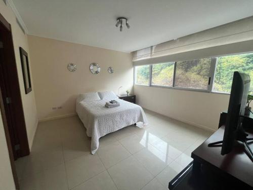 een witte slaapkamer met een bed en een raam bij Suite en Puerto Santa Ana! in Guayaquil