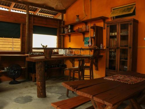 a living room with a wooden table and a desk at Valhalla Glamping House in Bombinhas