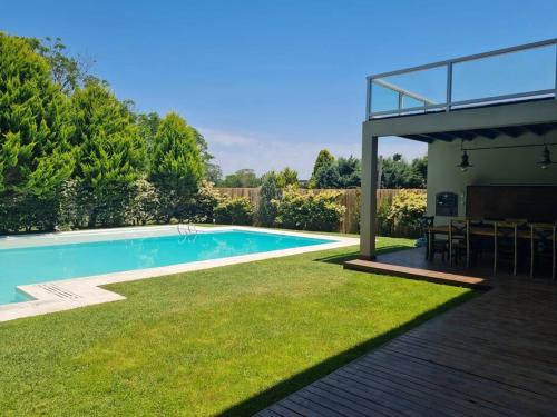 una piscina en un patio con mesa y sillas en Villa de Diseño exclusivo en Belén de Escobar