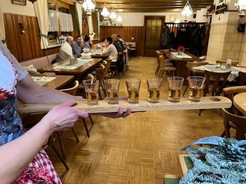 a person holding a tray of glasses of beer at Naturfreundehaus Brend in Neuweg