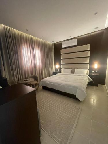 a bedroom with a large bed and a desk at استديو فندقي فاخر in Riyadh