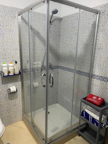 y baño con ducha y puerta de cristal. en Kech Days appartement près de l'aéroport en Marrakech