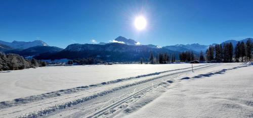 a snow covered field with the sun in the sky at Ferienwohnung Lechleitner in Reutte