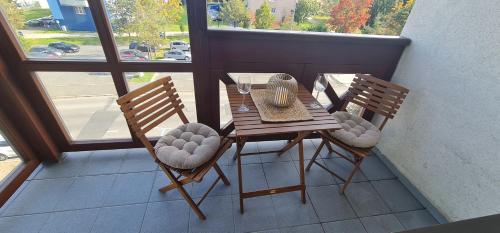 a balcony with a table and two chairs on a balcony at Tatra diamond appartement 70m2 v centre s parkovanim zadarmo in Poprad