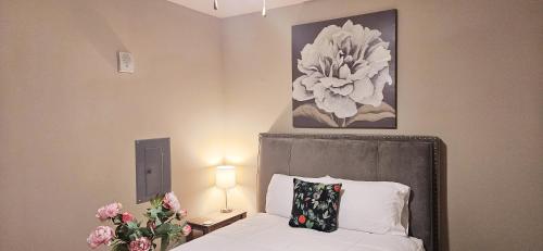 - une chambre avec un lit et une photo de fleurs dans l'établissement Atlanta Buckhead Style, à Atlanta