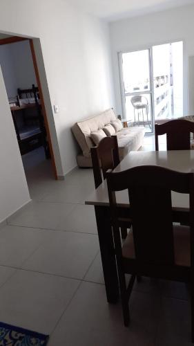 ein Wohnzimmer mit einer Couch und einem Tisch und Stühlen in der Unterkunft Apartamento no Condomínio da Fé in Cachoeira Paulista