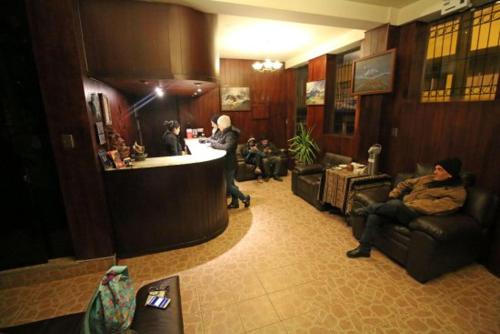 a lobby with people sitting in chairs and a bar at Camino Real Puno in Puno