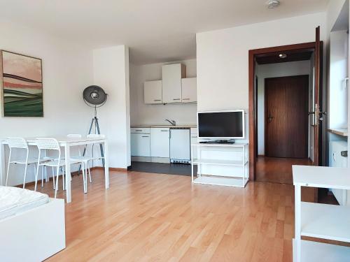 a kitchen and living room with a table and a television at Apartment bei Wasserburg am Inn in Soyen
