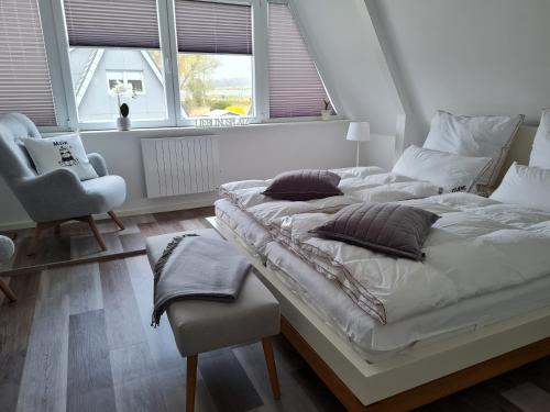 a bedroom with two beds and a chair and windows at Schlei-Perle in Kappeln