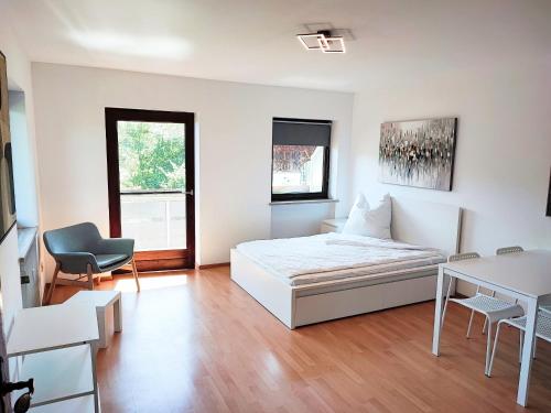 een witte kamer met een bed en een bureau bij Apartment bei Wasserburg am Inn in Soyen