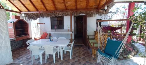 a patio with a white table and chairs on it at Hugo's Relax Home (Casa) in Ayangue
