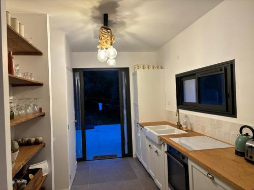 d'une cuisine avec un comptoir, un évier et une fenêtre. dans l'établissement VILLA VUE MER sur la presqu'ile de GIENS, à Hyères