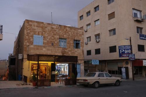 une voiture garée devant un bâtiment dans l'établissement Beit alkaram, à Al-Karak