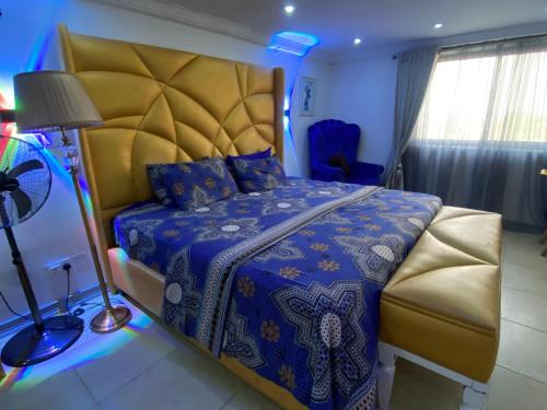 a bedroom with a king sized bed with a blue comforter at The Residence Golden Tulip 2 Bedroom Apartment, Amuwo Lagos, Nigeria in Lagos