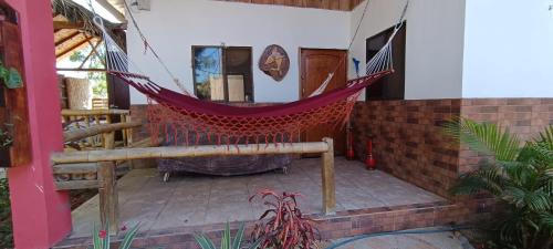 a hammock on a porch with a bench at Hugo's Relax Home (Casa) in Ayangue