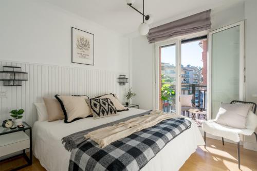 um quarto branco com uma cama e uma janela em AkomodaT en luminoso y acogedor cercano a la playa y Bilbao em Urduliz